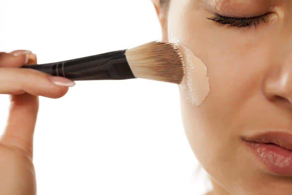 mulher passando maquiagem no rosto